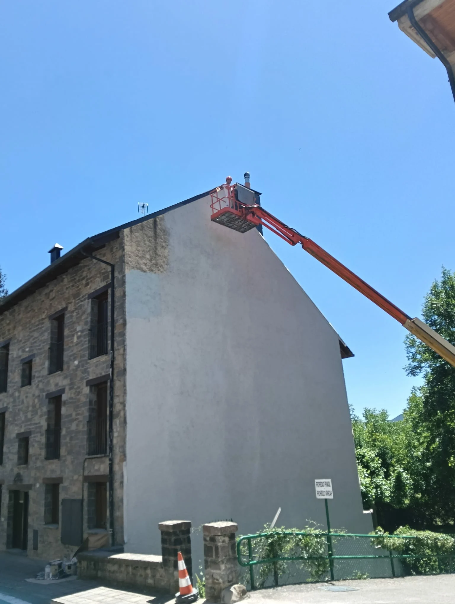 Pintor pintando fachada de edificio en Huesca
